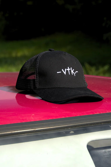 Černá kšiltovka VTK – pohled zepředu na kapotě červené Felicie
