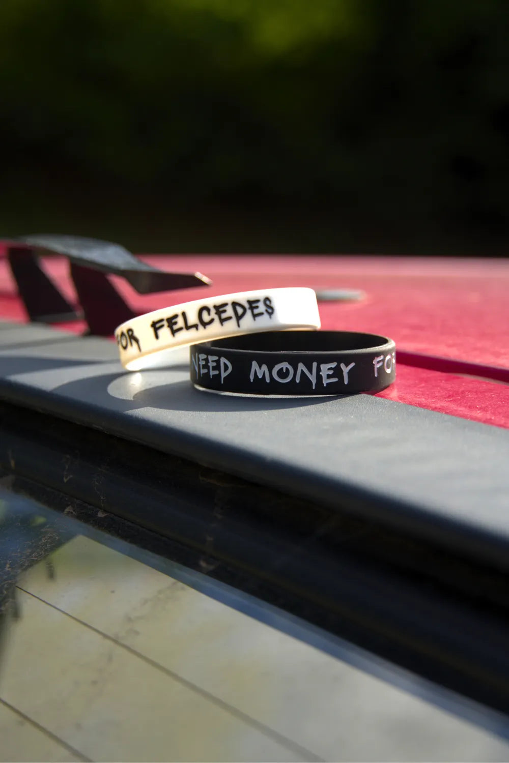 Černý a bílý náramek I Need Money for Felcedes na střeše červené Felicie