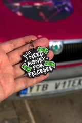 Přívěsek I Need Money for Felcedes se zelenými bankovkami na dlani